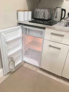 an open refrigerator with its door open in a kitchen at Shimna Vale Studio in Newcastle
