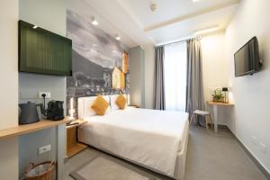 a hotel room with a bed and a flat screen tv at Avenue Boutique Hotel in Como