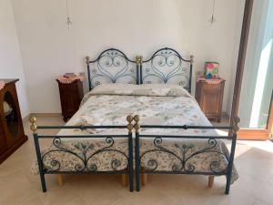 a bedroom with a bed with a wrought iron frame at Casa della Resistenza in Presicce +10 photos