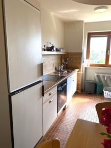 a kitchen with white cabinets and a sink at Auszeit in Immenstaad am Bodensee