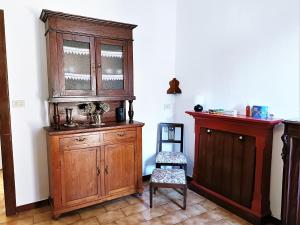 Cette chambre comprend une armoire en bois et une chaise. dans l'établissement Holiday home in Maccagno con Pino e Veddasca with garden, à Maccagno Inferiore