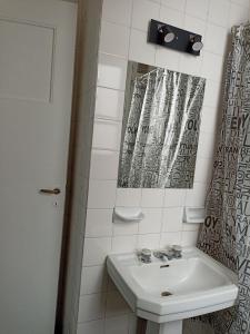 Baño blanco con lavabo y espejo en Hermoso departamento 2 ambientes en Microcentro en Buenos Aires