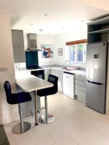 uma cozinha com uma mesa e cadeiras e um frigorífico em The Cart House - Staverton Cheltenham em Cheltenham