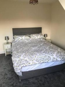 a bedroom with a large bed with two night stands at Blacklaines Annexe Birdlip - Pet friendly! in Gloucester
