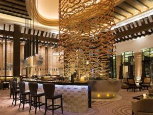 a hotel lobby with a large bar with chairs at Hotel Shanghai Sheshan Oriental - Handwritten Collection in Songjiang