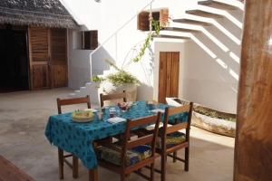 uma mesa de jantar com uma toalha de mesa azul e cadeiras em Villa Moringa lodge 