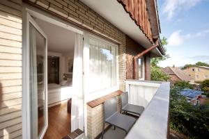 einen Balkon mit einem Tisch und Stühlen sowie ein Schlafzimmer in der Unterkunft Der Kleine Hans in Sankt Michaelisdonn