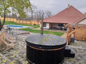 ein großes Fass mit einem Brunnen im Hof in der Unterkunft Sauna Fifty Rekreációs Szaunapark in Vaszar