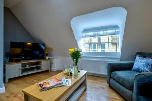 a living room with a couch and a tv at Stylish Stamford Centre 2 Bedroom Apartment - St Pauls Apartments - B in Stamford