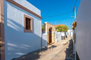 a narrow alley with white buildings and a window at Casa Aestas in Lachania