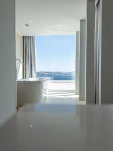 a white bathroom with a view of a window at Otantus Hotel in Muros