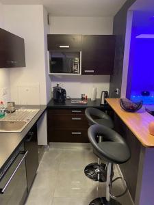 una cocina con 2 taburetes frente a un mostrador en Passion Airbnb, en Estrasburgo