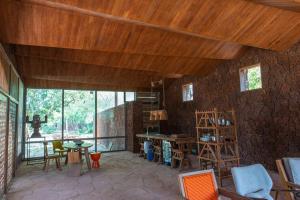 a room with a wooden ceiling and a table and chairs at Maison Pierres in Toubab Dialaw