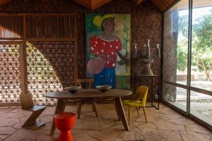 una mesa y sillas en una habitación con una pintura en Maison Pierres, en Toubab Dialaw