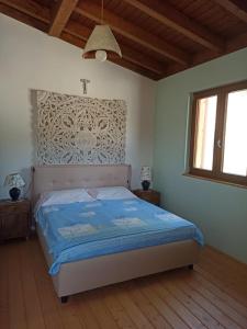 1 dormitorio con 1 cama con una cruz en la pared en La Casa dei Sogni, en Agira