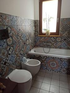 y baño con aseo, bañera y lavamanos. en La Casa dei Sogni, en Agira