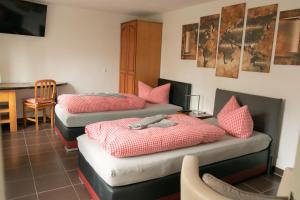 three beds in a room with a table and chairs at Pension Scheffler in Potsdam