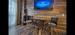 a room with a table and chairs and a tv on a wall at Апартамент Bella Casa in Beli Iskar