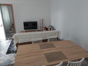 stół z 2 krzesłami i telewizor w pokoju w obiekcie Εirene room w Chalkidzie