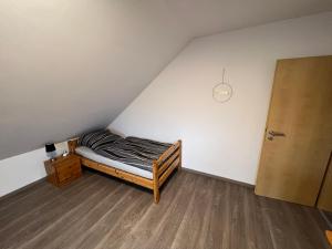 a small bedroom with a bed and a door at Ferienwohnung Löwen in Wabern