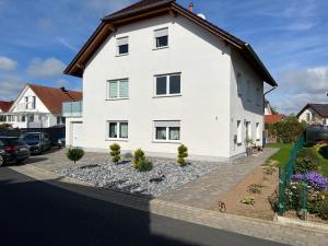 a white house with a landscaping at Ferienwohnung Löwen in Wabern