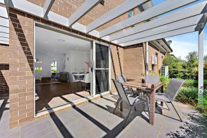 un patio con mesa y sillas y un edificio en AirCabin - Norwest - Luxury Lovely - 4 Beds House, en Baulkham Hills