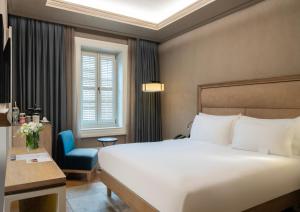 Habitación de hotel con cama y silla azul en 10 Karakoy, en Estambul