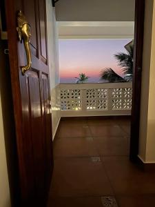 a door to a balcony with a view of the ocean at Buddha Beach Hotel in Kovalam