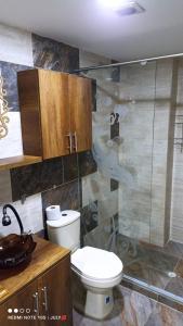 a bathroom with a toilet and a glass shower at Casa víctoria in Bello