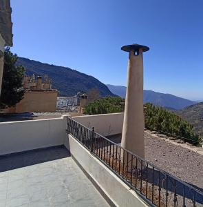 a lighthouse on top of a building with mountains in the background at Apartamentos Casalpujarra in Bubión