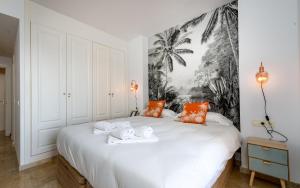a bedroom with a large white bed with orange pillows at Coto Real 2412 KHIOS in San Luis de Sabinillas +36 photos