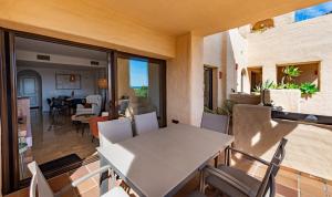 a room with a table and chairs on a balcony at Coto Real 2412 KHIOS in San Luis de Sabinillas