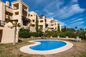 a resort with a swimming pool in front of a building at Coto Real 2412 KHIOS in San Luis de Sabinillas