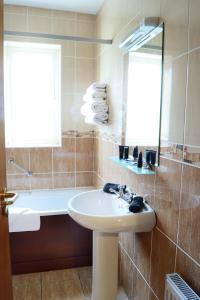bagno con lavandino, vasca e specchio di Donegal Manor Huge Luxury Self Let a Donegal