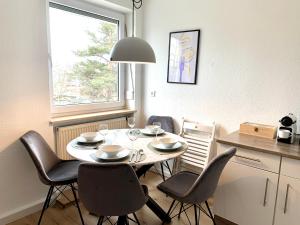 a dining room with a table and chairs and a window at Antoni Homes 2-4 Personen I 2 Schlafzimmer I Messe I Uni I Arena in Augsburg