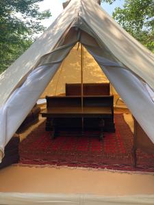 a tent with a bench in the middle of a rug at Go Wild Glamping in Sibiu