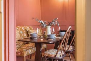 a dining room with a table with chairs and a couch at Rogue's Cottage - Secluded gem by the sea in Deal