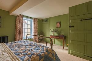 a bedroom with green walls and a bed and a window at Rogue's Cottage - Secluded gem by the sea in Deal