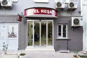 a coffee shop with a red sign on a building at Hotel Resat in Izmir