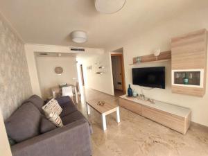 een woonkamer met een bank en een tafel bij ACV - Vila d´Orpesa X-1ªlinea planta 4 Norte in El Borseral