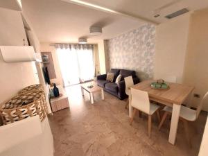 een woonkamer met een tafel en een bank bij ACV - Vila d´Orpesa X-1ªlinea planta 4 Norte in El Borseral