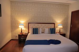a large bed in a hotel room with two lamps at Tolip Olympia Hotel in Addis Ababa