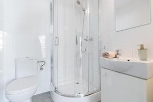 uma casa de banho com um chuveiro, um WC e um lavatório. em Apartamenty - Sztutowo Zalewowa em Sztutowo