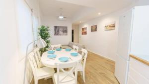 un comedor blanco con una mesa y sillas blancas en RentalSevilla Disfruta por San Leandro en un alojamiento con 3 habitaciones en Sevilla