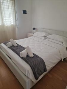 uma grande cama branca com duas toalhas em The Right Place 4U Roma Monteverde Al Palazzetto Apartment with Terrace&Garage em Roma