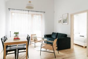 a living room with a couch and a table and chairs at manō in Barlinek