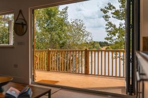 a room with a large sliding glass door to a deck at Lakeside Lodge- 'Swallow' in Bishampton