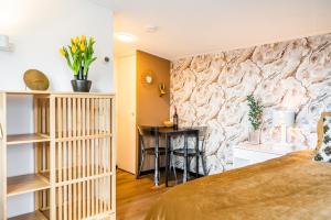 a bedroom with a stone accent wall and a desk at Charley's Wellness Suite in Westkapelle