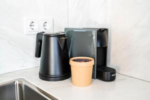 a coffee maker and a coffee cup on a kitchen counter at Charley's Wellness Suite in Westkapelle