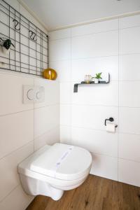 a white bathroom with a white toilet in it at Charley's Wellness Suite in Westkapelle